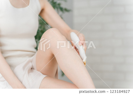 亞洲女性使用美容器滾輪去除小腿上的廢物 123184927