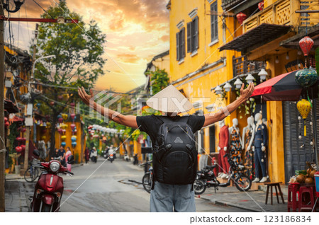 Asian male traveler tourist in traditional vietnamese Non La hat on street in old town in Hoi An city in Vietnam in Asia 123186834