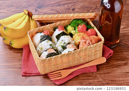 飯糰飯盒。鮭魚、野澤魚小沙丁魚、醃梅子。炸雞、蛋捲、綠花椰菜和小聖女果。 123186931