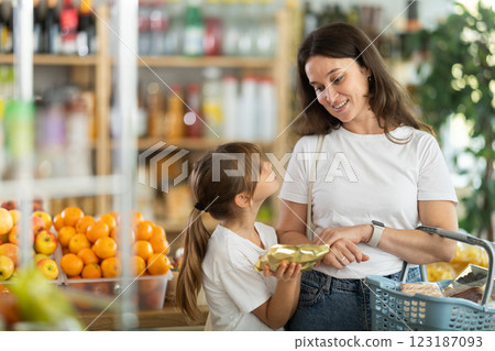Teenage girl and mother choose different products together in grocery supermarket Teenage girl and mother choose different products together in grocery supermarket 123187093