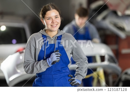 Service station young woman employee works in repair box, department 123187128