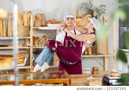 Girl and guy sellers in bakery are having fun and taking break from work, dancing and jumping. Girl and guy sellers in bakery are having fun and taking break from work, dancing and jumping. 123187143