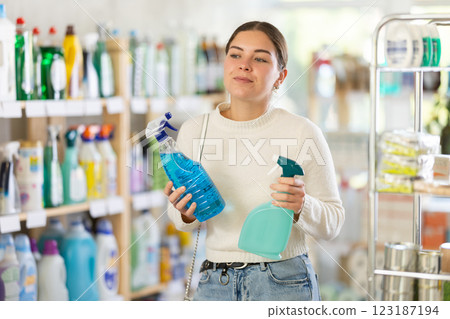 Woman choosing a cleaning spray Woman choosing a cleaning spray 123187194