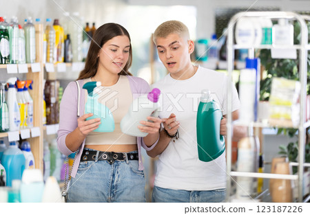 Couple man and woman choosing detergent and spray in store Couple man and woman choosing detergent and spray in store 123187226