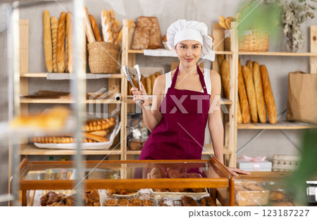 Young female seller standing in bake house, ready to greet customers Young female seller standing in bake house, ready to greet customers 123187227