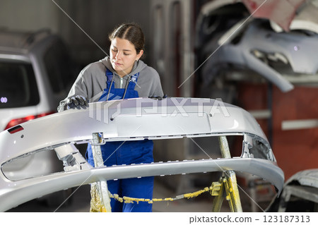 Service station young woman employee works in repair box, department Service station young woman employee works in repair box, department 123187313