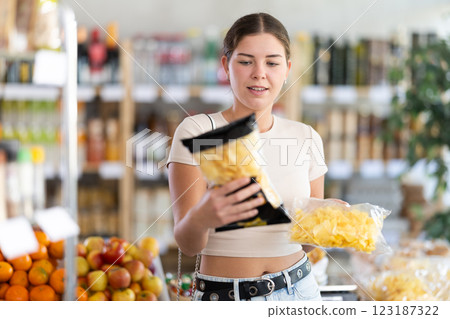 Young woman choosing chips in grocery store Young woman choosing chips in grocery store 123187322