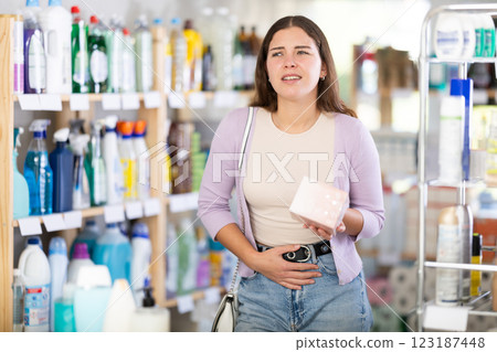 Woman with stomach pain chooses cosmetics 123187448