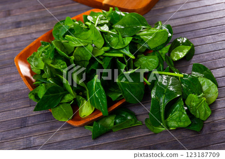 Fresh green spinach leaves on wooden table and in bowl Fresh green spinach leaves on wooden table and in bowl 123187709
