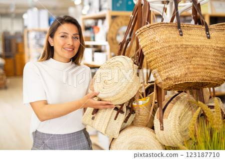 Young woman choosing straw bag at shop Young woman choosing straw bag at shop 123187710