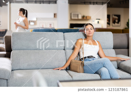 Young woman chooses sofa in store 123187861