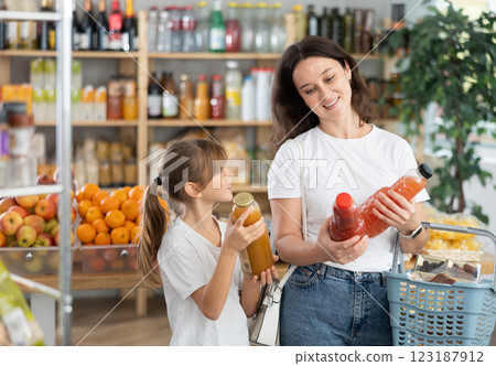 Child girl with mother choose consider juice Child girl with mother choose consider juice 123187912