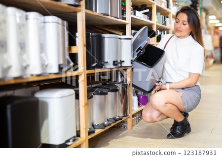 Woman choosing new trash bin at shop Woman choosing new trash bin at shop 123187931