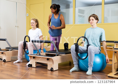 Pilates trainer teaching teens in gym Pilates trainer teaching teens in gym 123187964