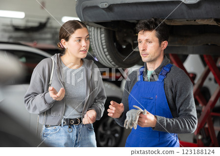 Male auto mechanic discussing with woman the cost and time to repair her car at car service 123188124