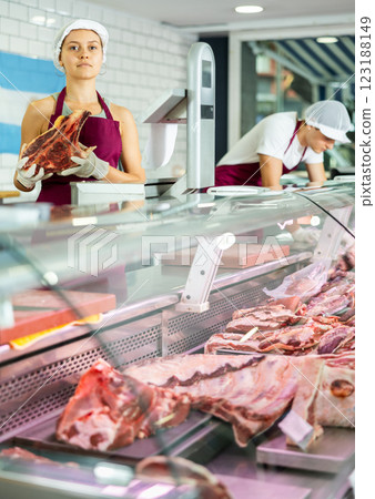 Girl seller works in specialized butcher shop Girl seller works in specialized butcher shop 123188149