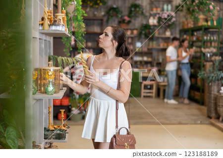 Woman selecting gift among stylish items in home decor store Woman selecting gift among stylish items in home decor store 123188189