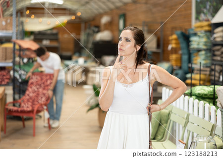 Thoughtful woman looking for furniture and accessories in garden store Thoughtful woman looking for furniture and accessories in garden store 123188213