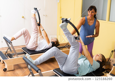 Teens training in pilates lessons led by female trainer 123188260