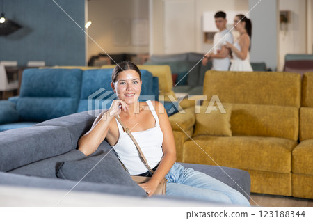 Young woman chooses sofa in store Young woman chooses sofa in store 123188344