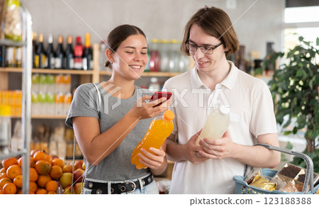 In shop youth spouses scan QR code and take reading drink package bottle using phone camera 123188388