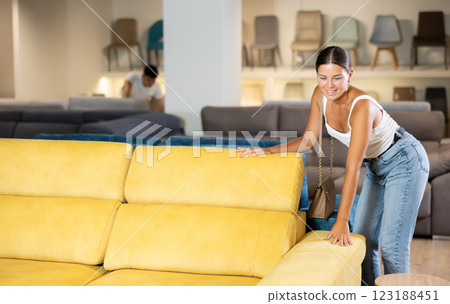 Young woman chooses sofa in store Young woman chooses sofa in store 123188451