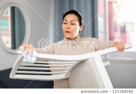 Woman washing chair during cleanup 123188590