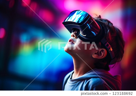 A young boy wearing a virtual reality headset is looking up at the sky. Concept of wonder and excitement as the boy explores the virtual world 123188692