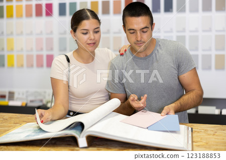 Married couple together choose color of ceramic tiles from catalog in hardware store Married couple together choose color of ceramic tiles from catalog in hardware store 123188853