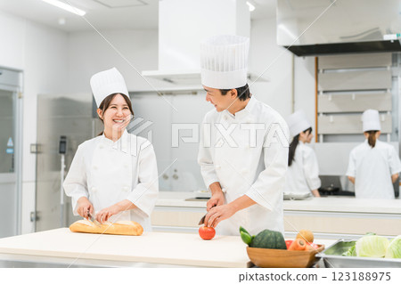 穿著廚師服的男女工作人員在廚房準備食物(廚師、廚師、生鮮市場、食物加工) 穿著廚師服的男女工作人員在廚房準備食物(廚師、廚師、生鮮市場、食物加工) 123188975