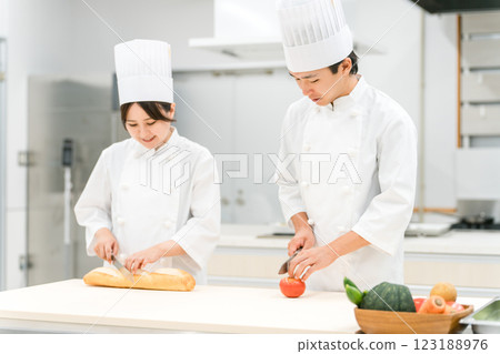 Male and female staff in chef coats preparing food in the kitchen (chefs, chefs, fresh market, food processing) 123188976