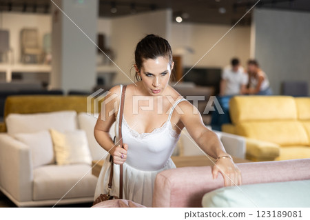 Young woman choosing convenient sofa in furniture shop 123189081