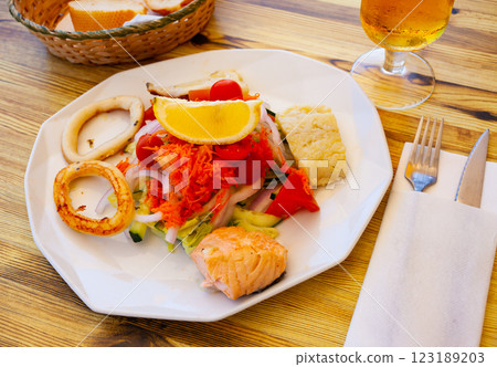 Vegetable salad with grilled squid rings and fish 123189203