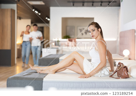 Young woman choosing convenient mattress in furniture shop 123189254