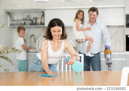 Happy family with two children doing cleaning in kitchen 123189282