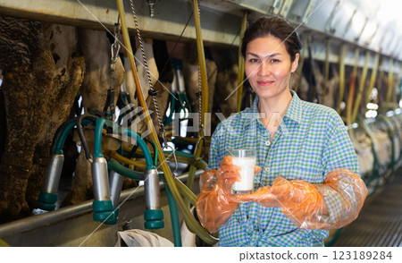 Farm worker standing with glass of milk 123189284