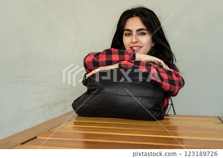 Young woman leaning on a pillow at a wooden table 123189726