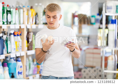 Male shopper chooses scented candles in supermarket for romantic evening 123189812