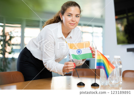 Young lady sets miniatures flags of LGBT and India before international negotiations 123189891