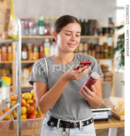 In shop youth girl scan QR code and take reading smoothie package bottle using phone camera In shop youth girl scan QR code and take reading smoothie package bottle using phone camera 123190062
