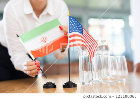 National flags of Iran and United States in hands of female office worker National flags of Iran and United States in hands of female office worker 123190063