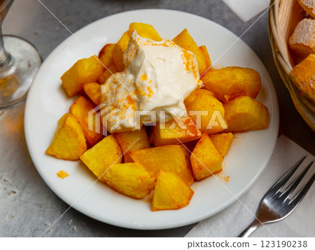 Spanish fried potatoes Patatas bravas served with cheese sauce and spicy sauce with paprika and chili Spanish fried potatoes Patatas bravas served with cheese sauce and spicy sauce with paprika and chili 123190238