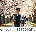 Elementary school students walking along the cherry blossom-lined street at the entrance ceremony 123190251