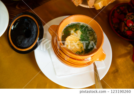 Top view of ear soup garnished in clay pot 123190260