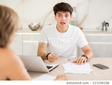 Young man listen attentively and intently to woman of seller, who tells about advantages of making microloan in credit institution Young man listen attentively and intently to woman of seller, who tells about advantages of making microloan in credit institution 123190286