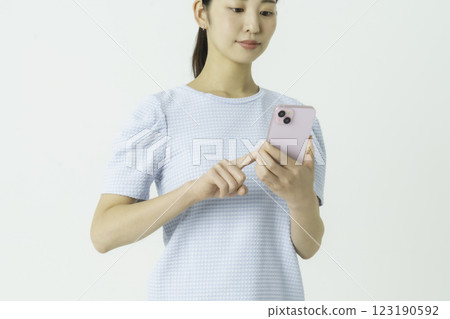 一位年輕女子操作智能手機的手的特寫 一位年輕女子操作智能手機的手的特寫 123190592
