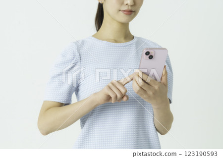 一位年輕女子操作智能手機的手的特寫 一位年輕女子操作智能手機的手的特寫 123190593