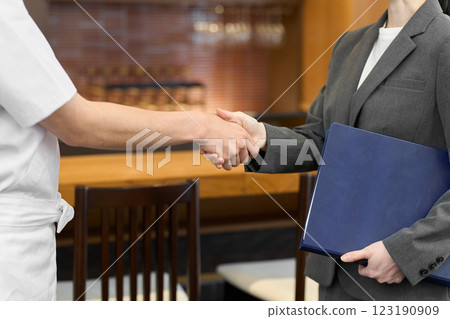 Businesswomen shaking hands at a restaurant Businesswomen shaking hands at a restaurant 123190909