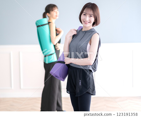 Smiling young woman with yoga mat 123191358