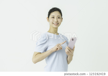 一個操作智能手機的年輕女子 一個操作智能手機的年輕女子 123192419